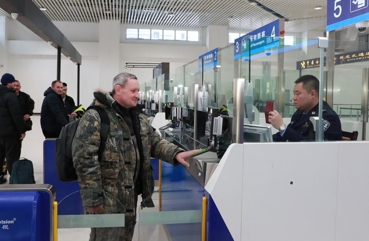 2024年12月10日，在黑河公路口岸旅檢大廳，黑河出入境邊防檢查站民警為首班次客車入境旅客辦理邊檢通關(guān)手續(xù)。當(dāng)日，中國黑河公路口岸—俄羅斯卡尼庫爾干公路口岸旅客運輸正式開通。新華社發(fā)（劉松攝）