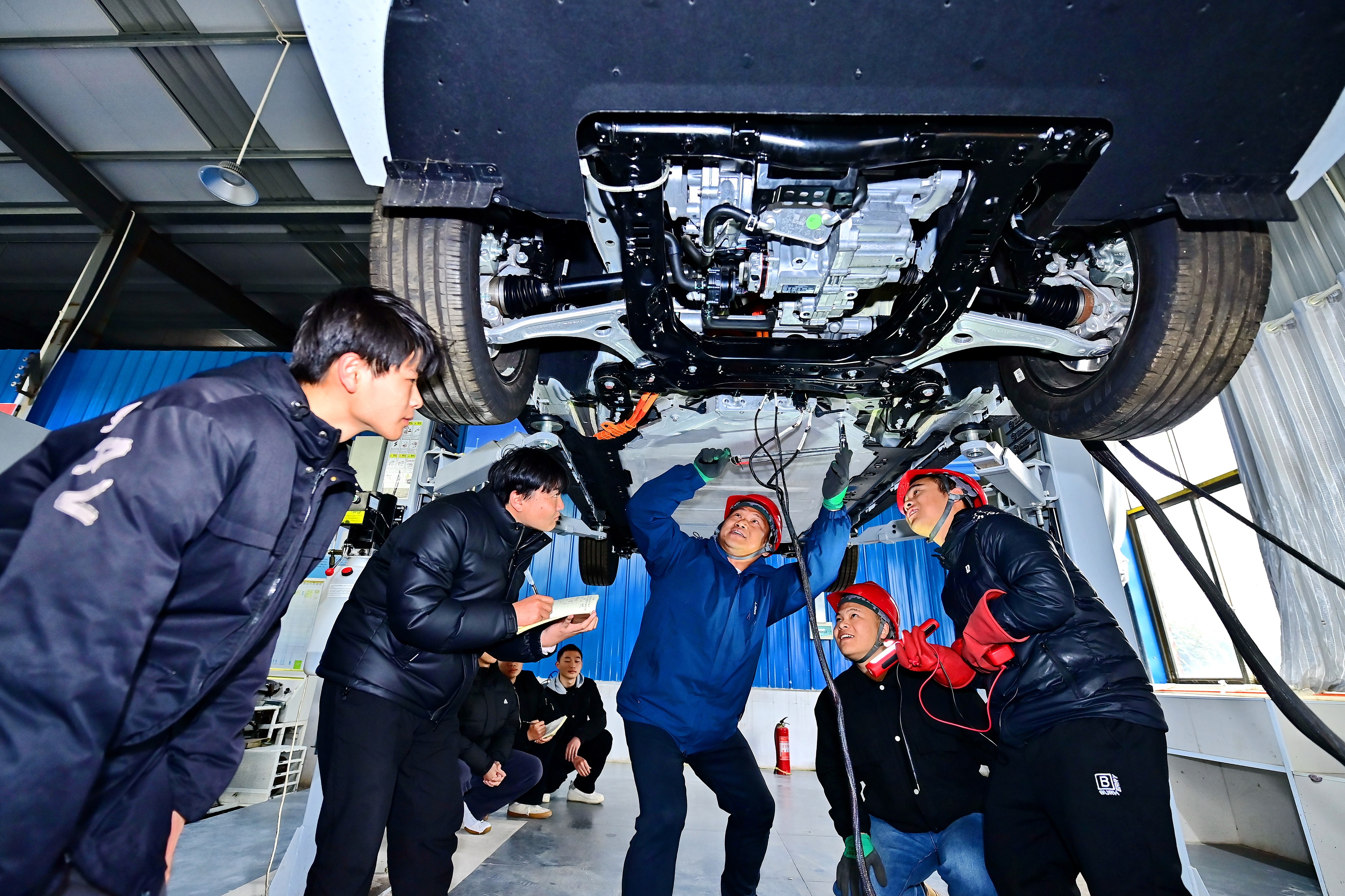 2025年2月，江西省宜春市，豐城市的一所技工學(xué)校實(shí)訓(xùn)基地內(nèi)，新能源汽車運(yùn)維專業(yè)學(xué)生在老師的指導(dǎo)下學(xué)習(xí)新能源汽車電池包檢修技術(shù)。