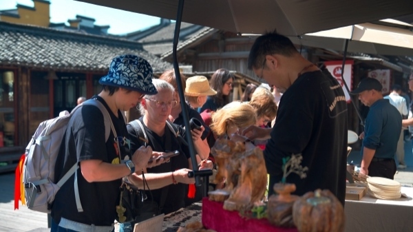 “五一”期間，游客正在烏鎮(zhèn)“水鄉(xiāng)碼頭”挑選購買文創(chuàng)產(chǎn)品。受訪者供圖