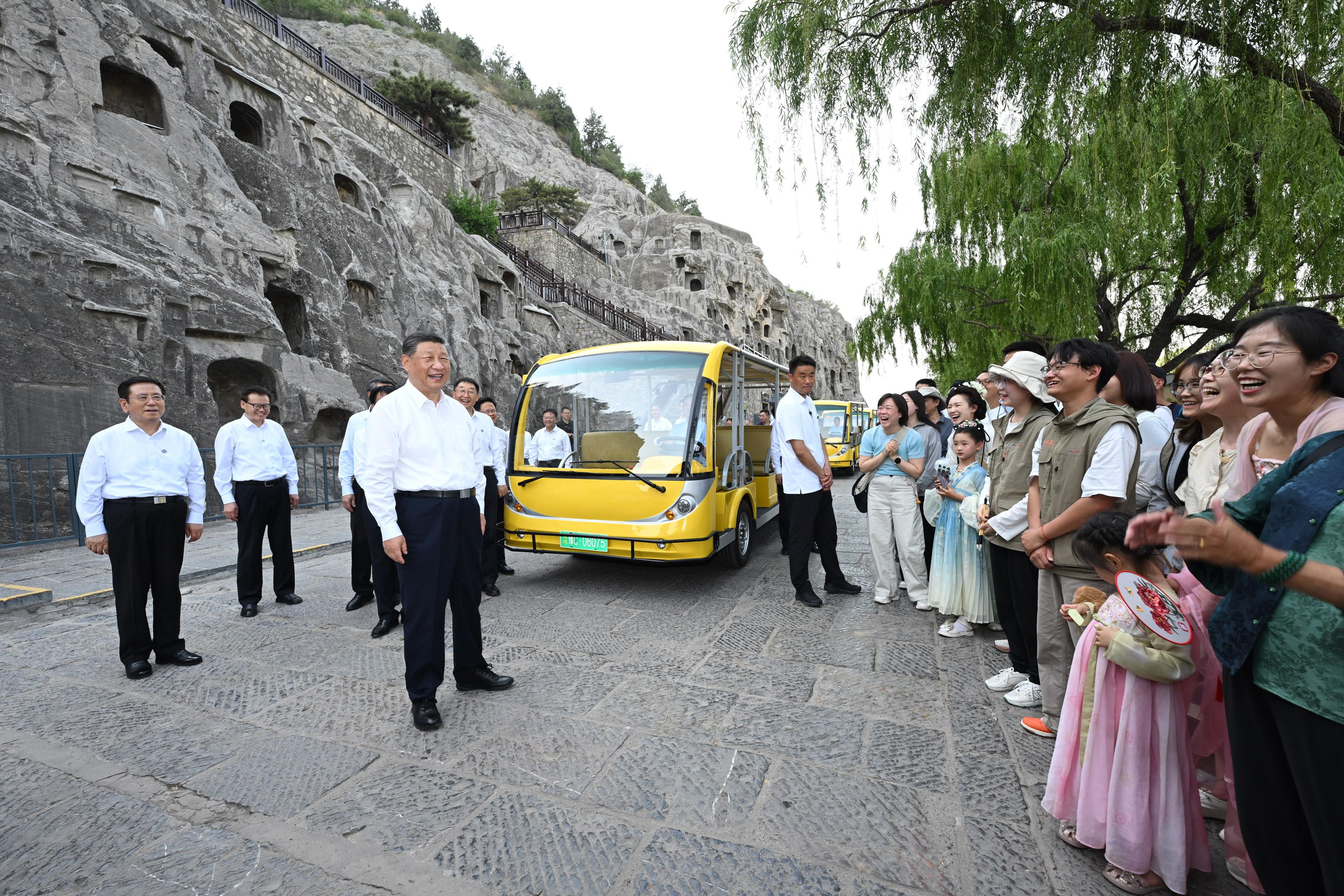 2025年5月19日，習近平總書記在洛陽龍門石窟考察時，同游客親切交流。