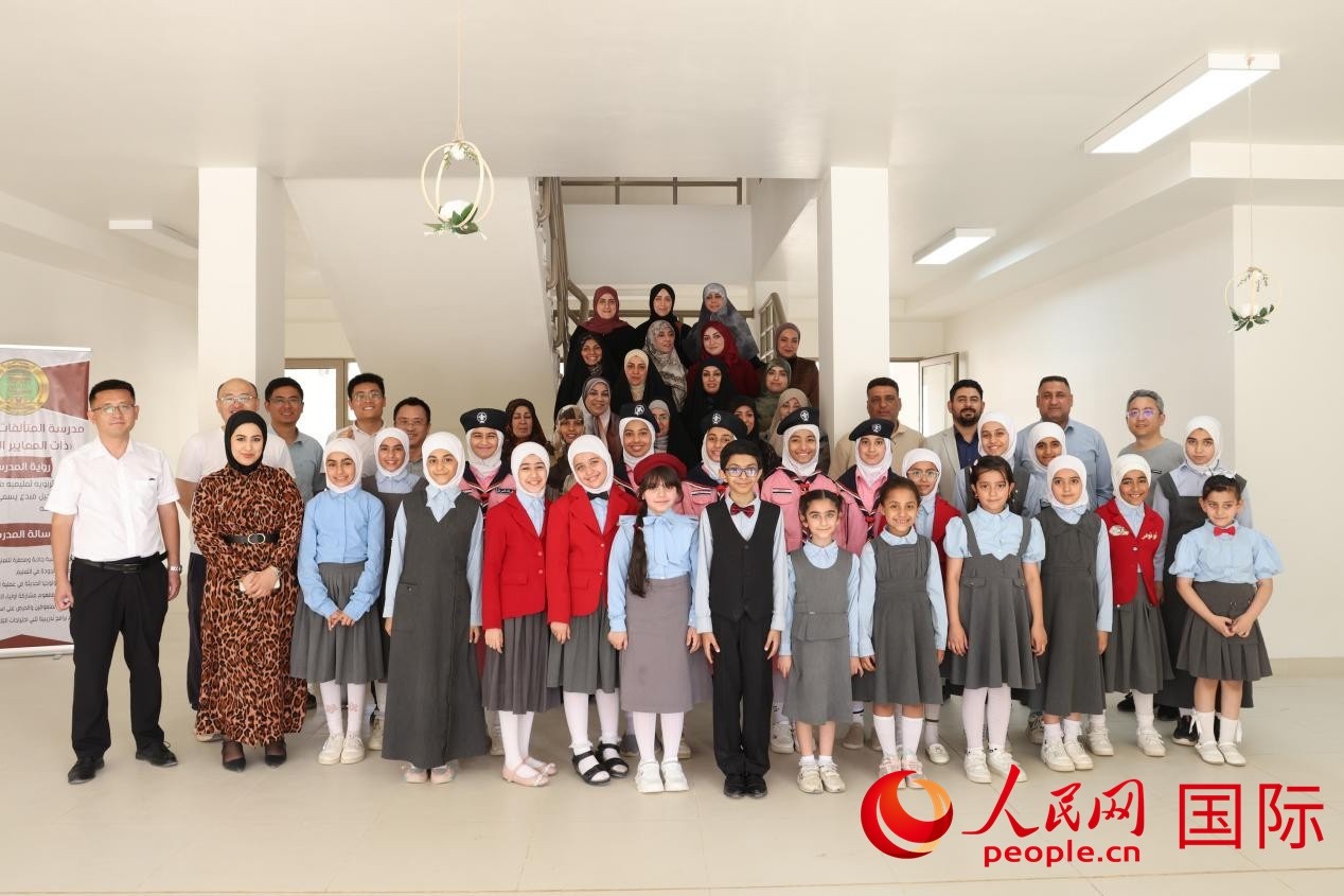中國電建員工與阿爾穆塔?阿里卡特國際學(xué)校的師生及政府官員等合影。人民網(wǎng)記者 薛丹攝