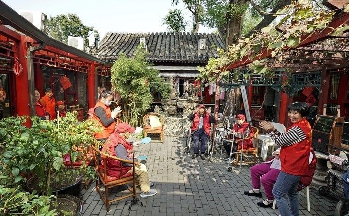 2024年10月12日，鐘樓灣胡同的老年人在社區(qū)內(nèi)的四合院養(yǎng)老驛站休閑。2017年起，北京市先后開展了兩輪背街小巷環(huán)境整治提升行動，完整保留了中軸線生活建筑群的歷史信息，并根據(jù)居民的生活和居住方式進行適配化的更新和改造，極大地改善了生活環(huán)境。2023年鐘樓灣胡同被評為“北京最美街巷”。