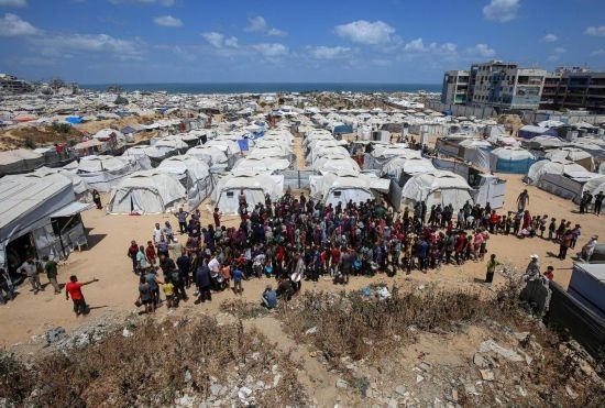 5月28日，人們在加沙城西部的沙提難民營等待領(lǐng)取救助食物。新華社發(fā)（里澤克·阿卜杜勒賈瓦德攝）