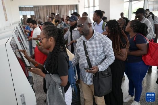 5月31日，在蒙內(nèi)鐵路內(nèi)羅畢站，乘客在自助取票機(jī)前排隊(duì)取票。新華社記者 楊光 攝