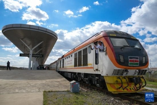 5月31日，在蒙內(nèi)鐵路內(nèi)羅畢站，機(jī)車駕駛員蔣立平（右）和博爾在即將開往蒙巴薩的E2次列車上揮手致意。新華社記者 楊光 攝