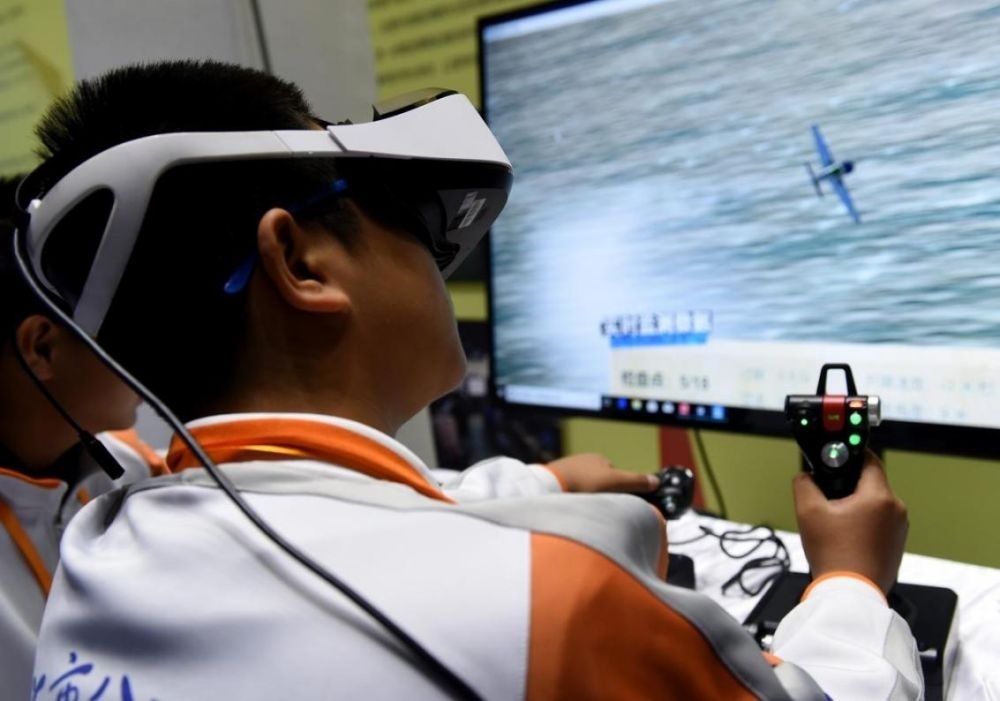 北京市八一學(xué)校的學(xué)生在北京市中小學(xué)生特色科技活動(dòng)展示上體驗(yàn)VR技術(shù)（2018年11月24日攝）新華社記者 羅曉光 攝。
